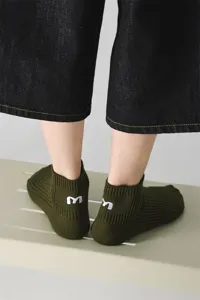 Nahaufnahme von dunkelgrünen gerippten Kurzsocken mit weißem Stickbuchstaben an der Ferse.