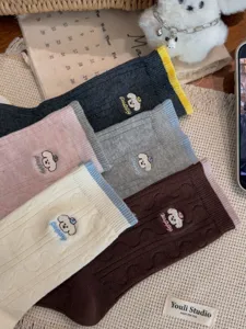 Nahaufnahme Detail von süßen Hund bestickten Baumwoll-Mittelsocken in vielen Farben.