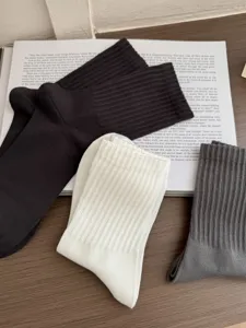 Close up detail of mens breathable cotton mid tube socks in black white and grey colors.