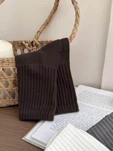 Detailed shot of men's ribbed mid-tube socks in dark brown, textured cotton knit.