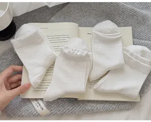 Vue détaillée de chaussettes blanches en coton avec bordure en dentelle délicate et élégante.