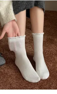 Vue détaillée de chaussettes mi-hautes blanches en coton avec bordure volantée et maille ajourée.