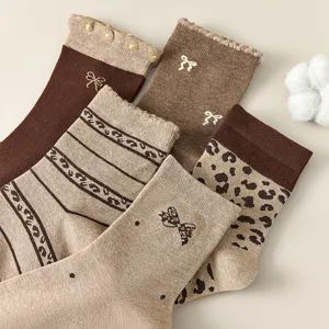 Set di calze al polpocchio marroni vintage da donna con fiocchi graziosi e motivi leopardati.