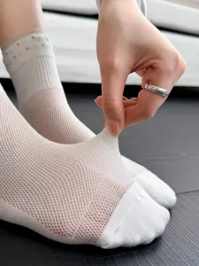 Detail view of breathable white mesh crew socks showing high elasticity and soft texture.