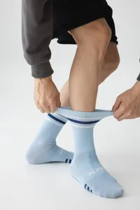 Detailed view of men's blue crew sports socks featuring contrast stripes and stretch fit.