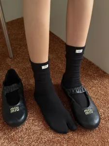 Calzini neri a punta divisa con etichetta egg abbinati a scarpe basse molto eleganti.