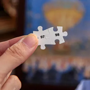 Gros plan sur le detail d'une piece de puzzle en carton numerotee pour puzzle de paysage nocturne.