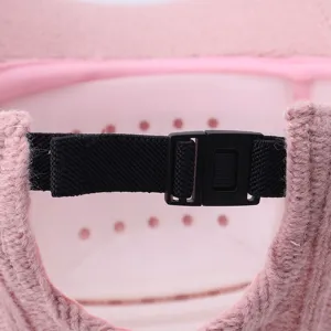 Detail view of the adjustable strap and plastic buckle on a stylish pink knit baseball cap.