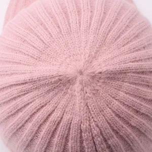 Close up detail of the soft pink knitted baseball cap texture, cozy winter warm hat style.
