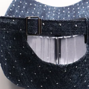 Detalle de la parte trasera de la gorra de mezclilla con diamantes y hebilla de metal.