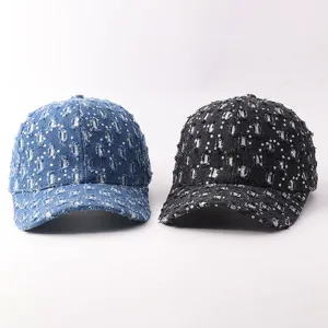 Vista detallada de gorras de béisbol de mezclilla desgastada con lentejuelas brillantes.