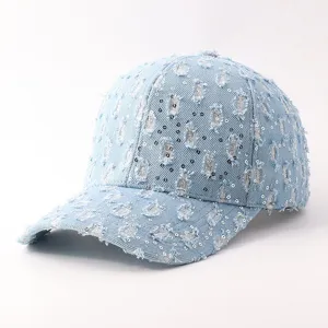 Detalle de gorra de béisbol de mezcla de denim azul claro con roturas y pedrería