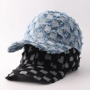 Primer plano de gorras de béisbol de mezclilla desgastadas y apiladas con patrón de cuadros y bordes.