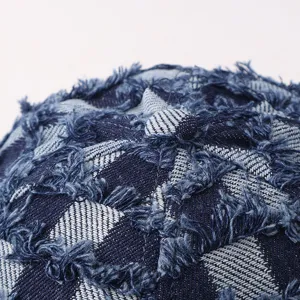 Primer plano de la textura de gorra vaquera de cuadros con bordes deshilachados.