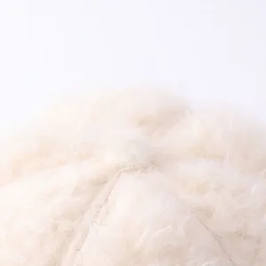 Primer plano detalle de la textura de tela de gorro de invierno cálido y suave, material crema.