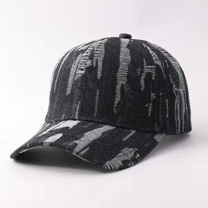 Primer plano de la gorra de béisbol de denim negro con patrones de rayas blancas.
