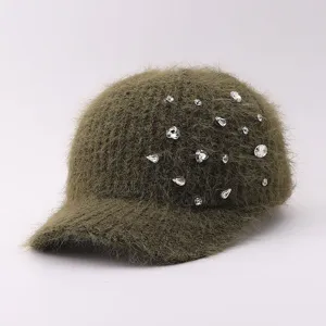 Détail en gros plan d'une casquette de baseball en tricot duveteux vert olive avec des strass.