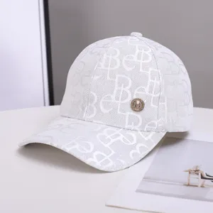 White monogram print baseball cap detail, featuring metallic M logo and wide brim for autumn sun.