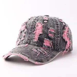 Distressed denim baseball cap detail showing unique ripped pink fabric elements and vintage wash.
