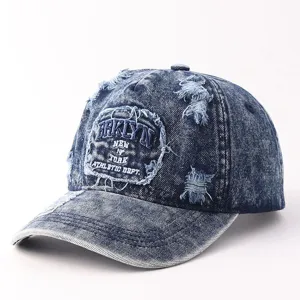 Close-up van een verwassen denim baseballpet met stijlvol borduursel aan de voorkant en scheuren.
