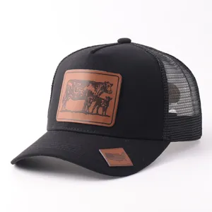 Primer plano detallado de la gorra trucker negra de malla con parche de cuero fino.
