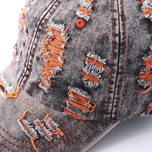 Distressed denim baseball cap detail, vintage colorful ripped design with orange threads.