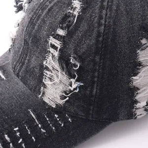 Close-up detail of a trendy distressed denim baseball cap, featuring unique ripped texture.