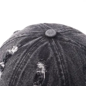 Close-up detail of the distressed denim baseball cap top with vintage wash texture.