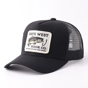 Detalle de gorra trucker negra con parche gráfico de pez y malla trasera transpirable.