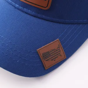 Detalle en primer plano de la visera de gorra azul con parche de cuero marrón grabado.