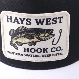 Primer plano de una elegante gorra trucker con un parche bordado detallado de un anzuelo de pesca.