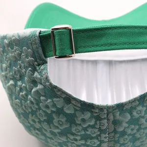 Detail view of green floral baseball cap showing adjustable strap and embossed flower fabric.