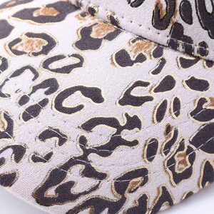 Dettaglio ravvicinato del berretto da baseball da donna con stampa leopardata e oro.