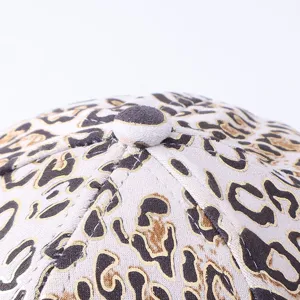 Dettaglio superiore berretto baseball stampa leopardata con trama oro brillante.