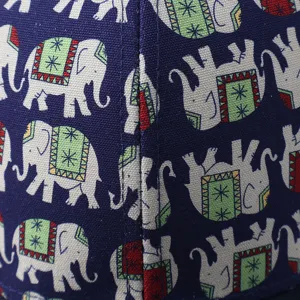 Close-up detail of ethnic elephant print fabric on baseball cap, blue textured weave.