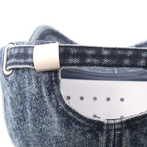 Gedetailleerde close-up van verstelbare metalen gesp en gewassen denim baseballcap.