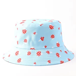 Detalle de sombrero de pescador con estampado de setas, patrón rojo y blanco en tela azul clara.