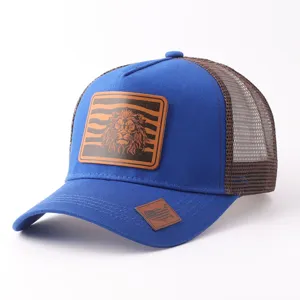 Gorra trucker azul con parte trasera de malla marrón transpirable y parche de cuero con león.