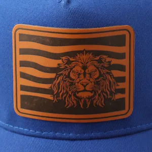Primer plano detalle de gorra trucker azul con parche de cuero de león, sombrero informal.