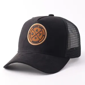 Gedetailleerd aanzicht van zwarte suèdine mesh trucker cap met ronde reliëf patch op de voorzijde.