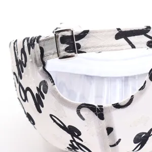 Detail view of a white baseball cap with black graffiti letters and metal adjustable buckle.