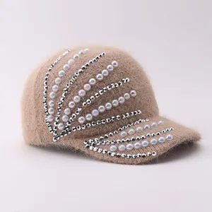 Detailed view of a cozy winter fuzzy knit baseball cap embellished with pearls and rhinestones.