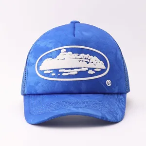 Front view detail of the blue trucker hat with white cruise ship graphic and mesh back.