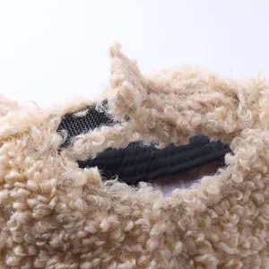 Primer plano detallado de la correa trasera ajustable en una gorra de lana de borrego beige.