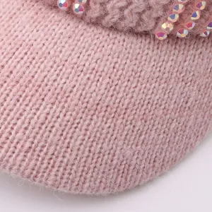 Gros plan sur la texture d'un bonnet d'hiver en tricot orné de strass en cristal scintillants.