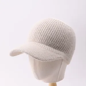 Primer plano de la gorra de béisbol tejida con textura acanalada suave y color beige cálido.