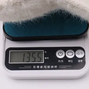 Detail view of winter warm fluffy knitted empty top hat being weighed, showing plush texture.