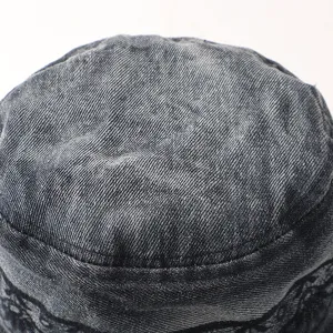 Κοντινή λήψη από καπέλο bucket denim με υφασμάτινη υφή και διακοσμητικά στοιχεία από δαντέλα.