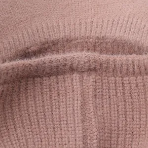 Primer plano detalle del tejido de gorro de invierno de punto marron rosa suave textura.