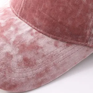 Dettaglio cappellino da baseball in velluto, morbido cappello rosa invernale con cuciture fini.